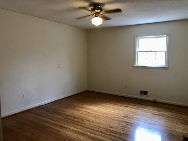 spare room with ceiling fan, hardwood / wood-style floors, and a textured ceiling