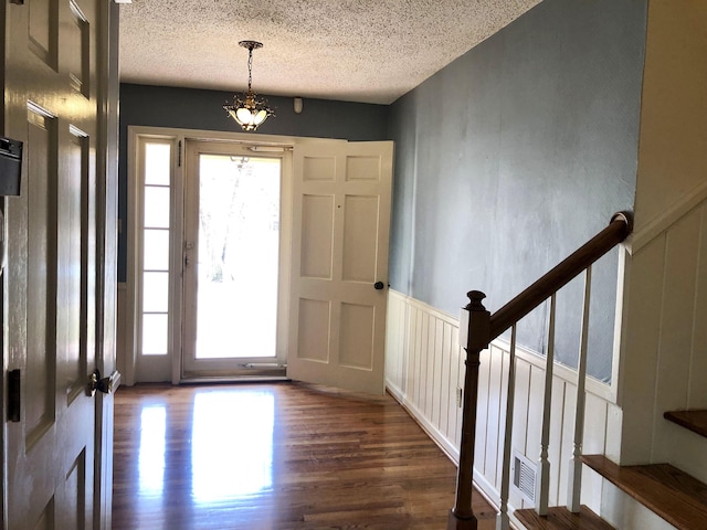 entrance foyer featuring dark hardwood / wood-style floors and a textured ceiling