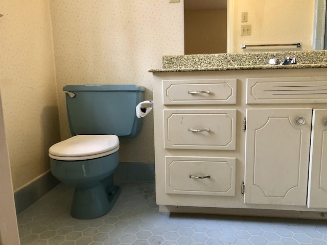 bathroom featuring vanity, tile patterned floors, and toilet