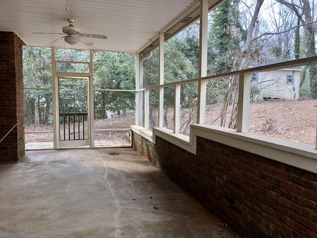 unfurnished sunroom featuring ceiling fan