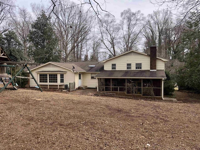 rear view of house with a playground and a sunroom