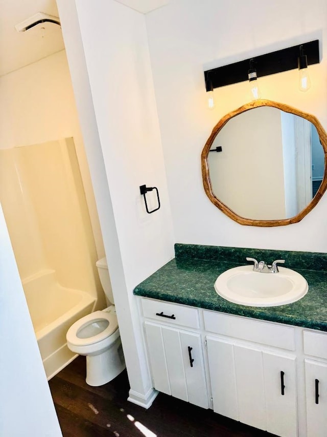 bathroom with vanity, shower / bath combination, wood finished floors, and toilet