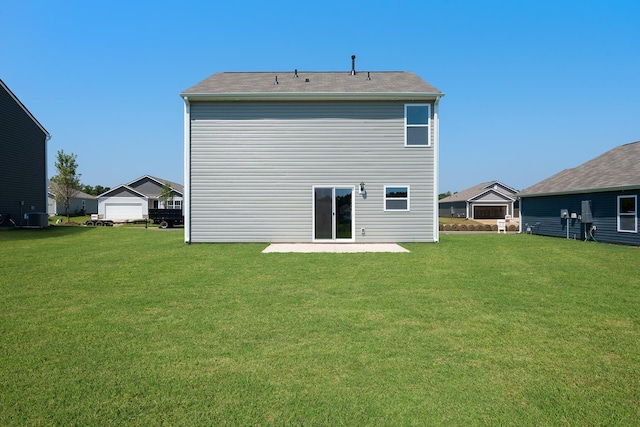 rear view of house featuring a patio, a yard, and central AC