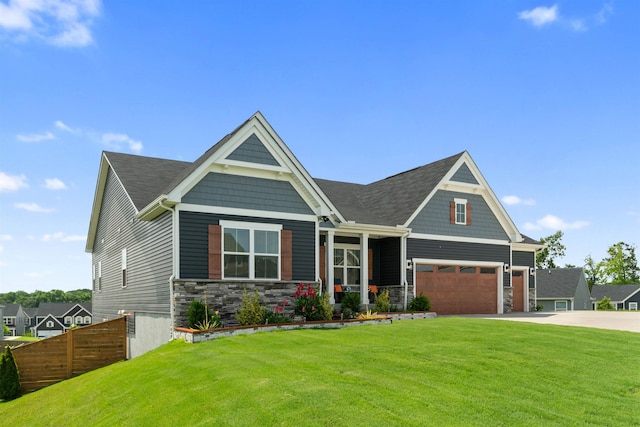 craftsman-style home featuring a garage, covered porch, and a front yard