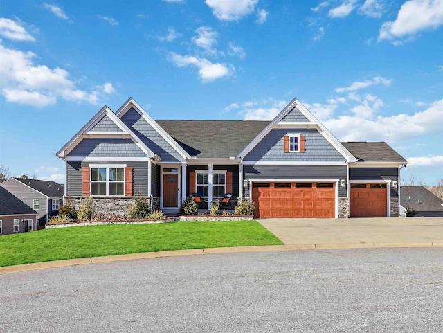 craftsman house with a garage and a front lawn