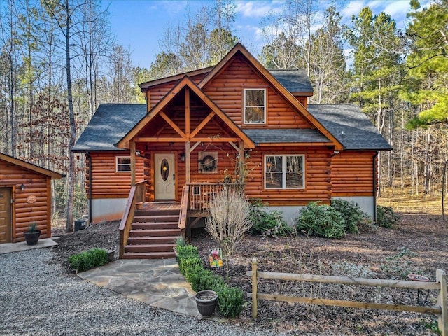 log home featuring roof with shingles and log siding