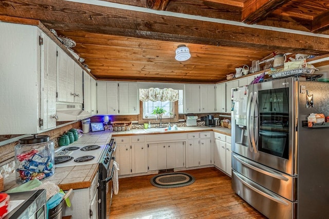 kitchen featuring stainless steel refrigerator with ice dispenser, tile countertops, sink, and white cabinets