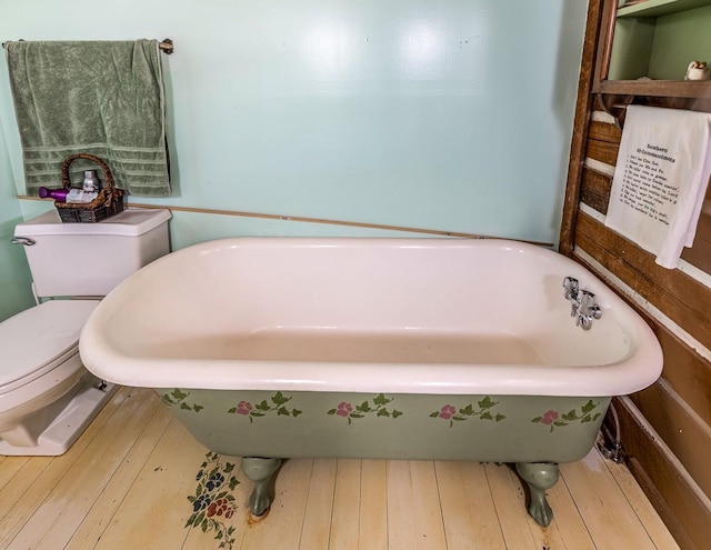 bathroom with wood-type flooring, a bathtub, and toilet