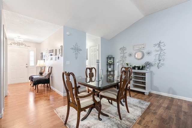 dining room featuring lofted ceiling and wood-type flooring