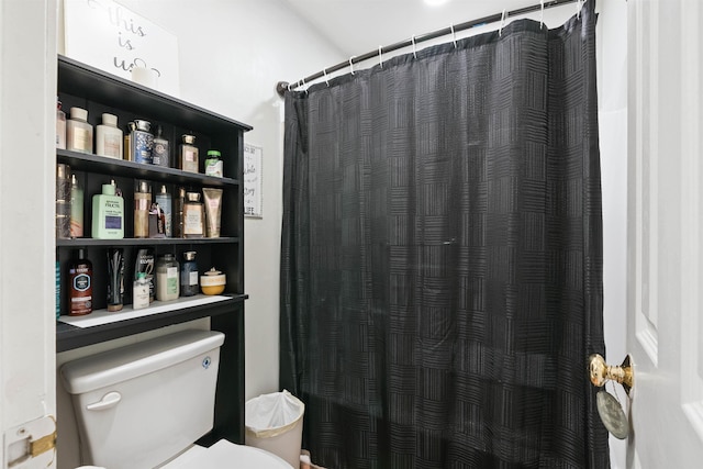 bathroom with a shower with curtain and toilet