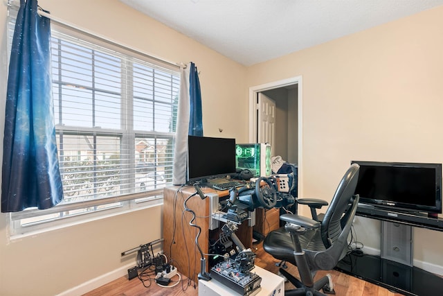 office area with light hardwood / wood-style floors and a textured ceiling