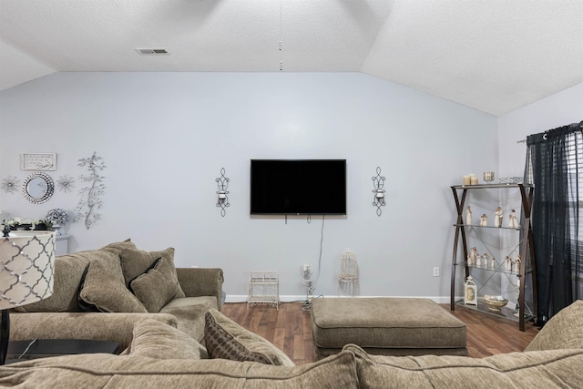 living room featuring vaulted ceiling, hardwood / wood-style floors, and a textured ceiling