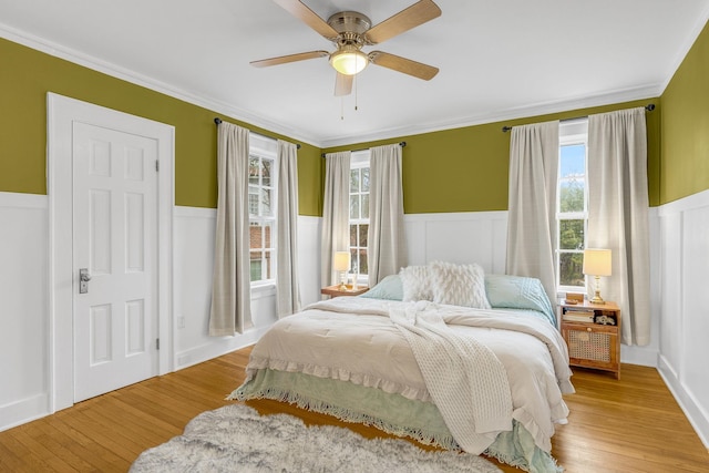 bedroom with ceiling fan, ornamental molding, and light hardwood / wood-style flooring