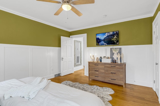 bedroom featuring ornamental molding, ceiling fan, and light wood-type flooring