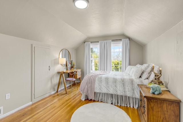 bedroom featuring lofted ceiling and light hardwood / wood-style flooring