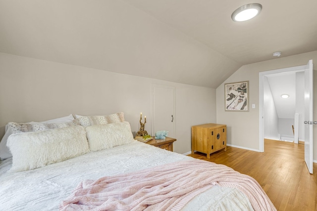 bedroom featuring hardwood / wood-style flooring and lofted ceiling