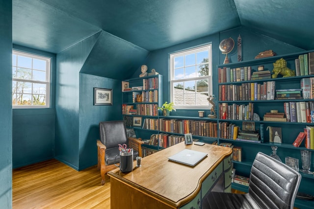 office space featuring wood-type flooring, vaulted ceiling, and a wealth of natural light