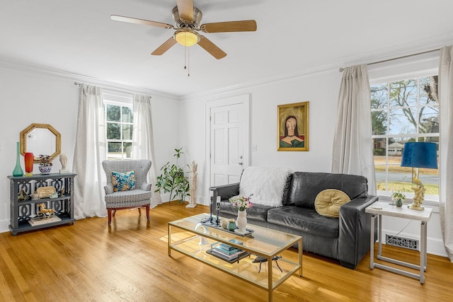 living room featuring crown molding, ceiling fan, and wood-type flooring