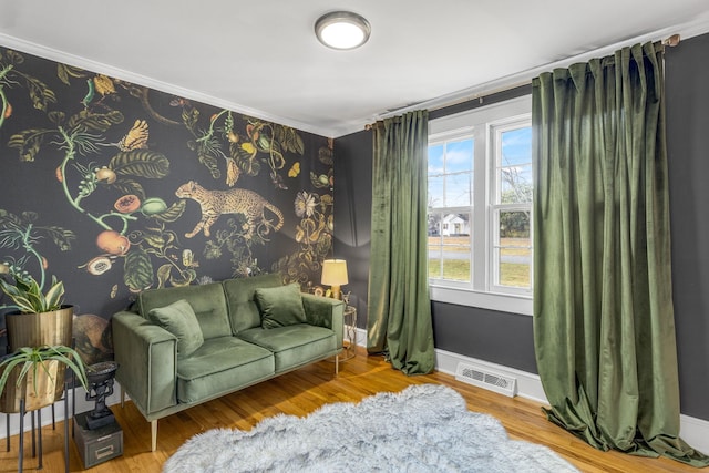 living area featuring hardwood / wood-style flooring and crown molding