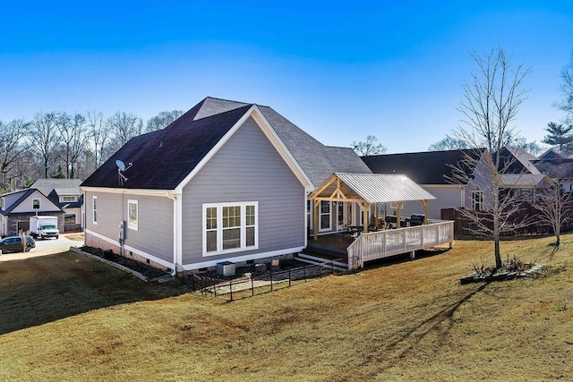 back of property featuring a wooden deck and a lawn