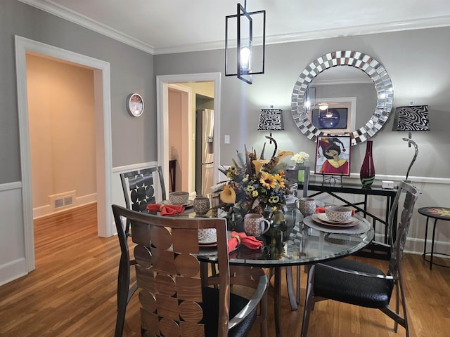 dining area featuring crown molding and hardwood / wood-style flooring