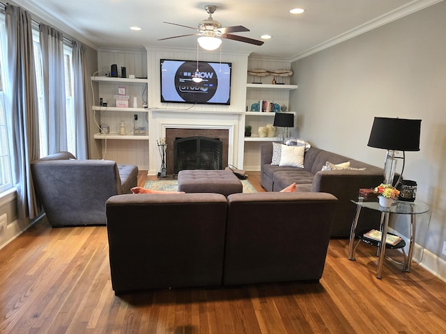 living room featuring crown molding, hardwood / wood-style floors, and ceiling fan