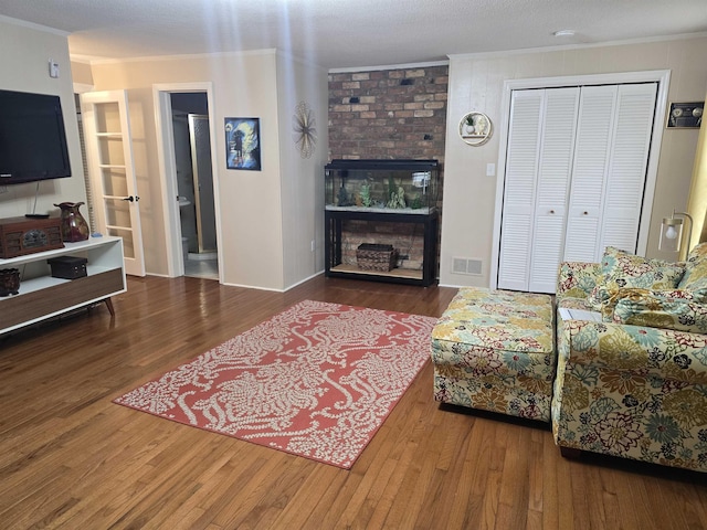 living room with hardwood / wood-style floors, a fireplace, and ornamental molding