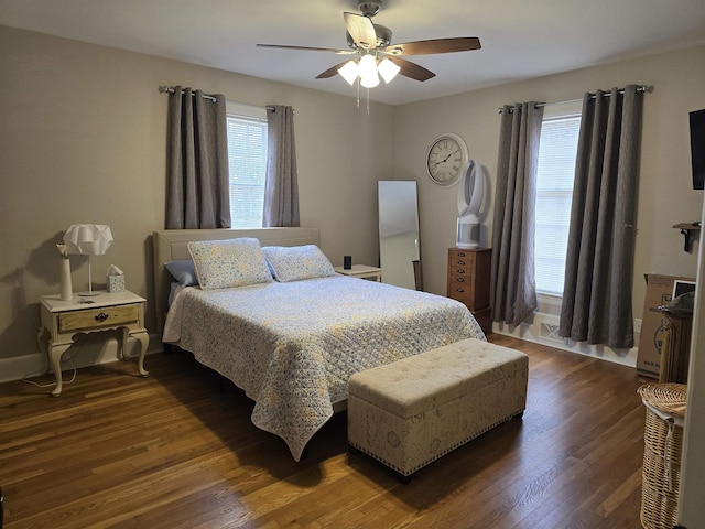 bedroom featuring multiple windows, dark hardwood / wood-style floors, and ceiling fan