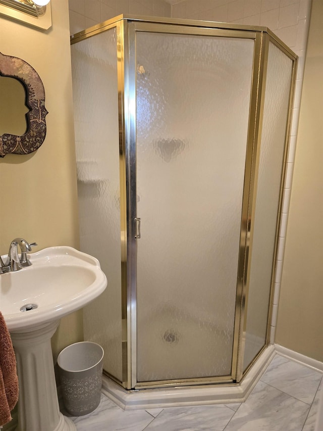 bathroom with sink and a shower with shower door