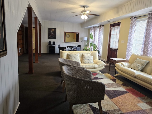 living room featuring ceiling fan and dark colored carpet