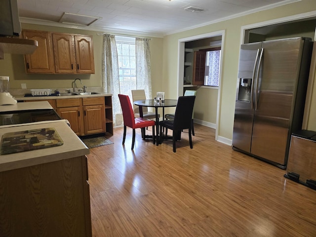 kitchen featuring ventilation hood, sink, stainless steel fridge, ornamental molding, and light hardwood / wood-style flooring