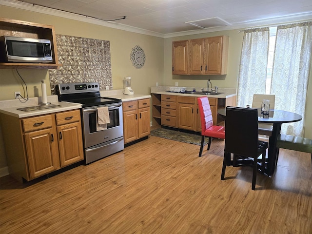 kitchen featuring sink, ornamental molding, stainless steel appliances, and light wood-type flooring