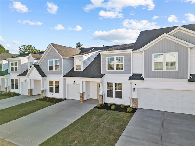 townhome / multi-family property featuring a garage and a front lawn