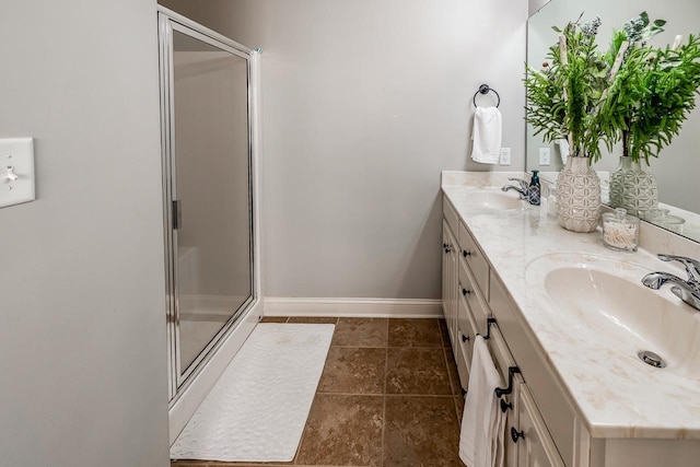 bathroom featuring a shower with door and vanity