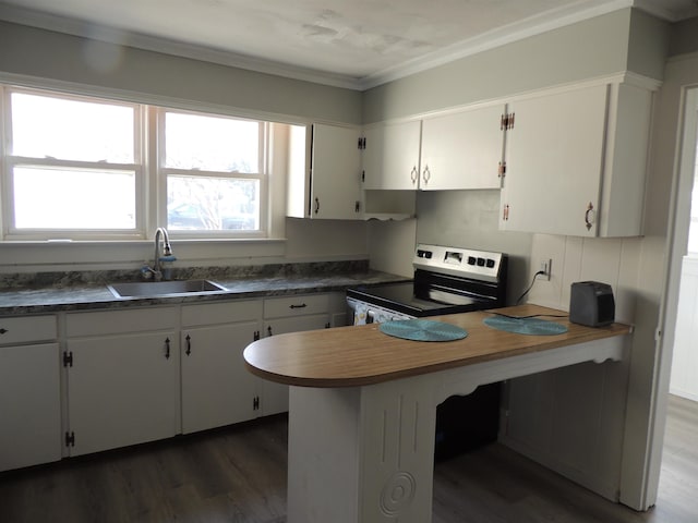 kitchen with sink, dark wood-type flooring, stainless steel range with electric cooktop, and white cabinets