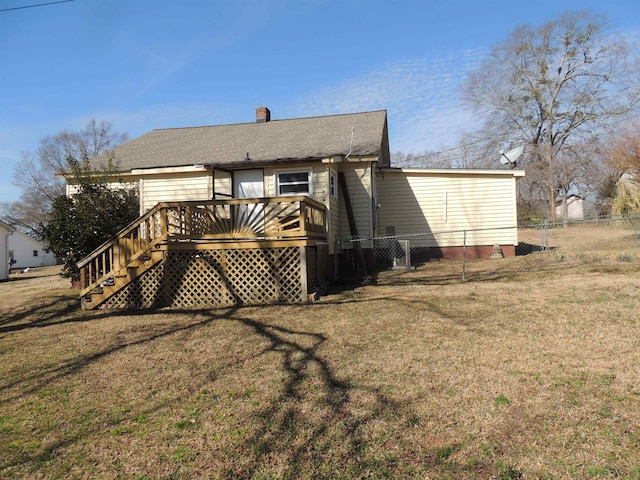 back of property with a yard and a deck