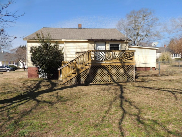 rear view of property with a yard and a deck