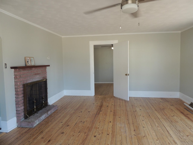 unfurnished living room with crown molding, a fireplace, ceiling fan, and light wood-type flooring