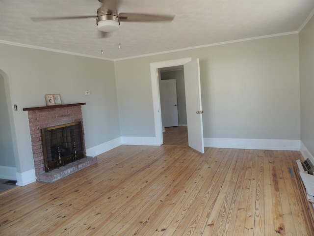 unfurnished living room with crown molding, a brick fireplace, and light hardwood / wood-style flooring