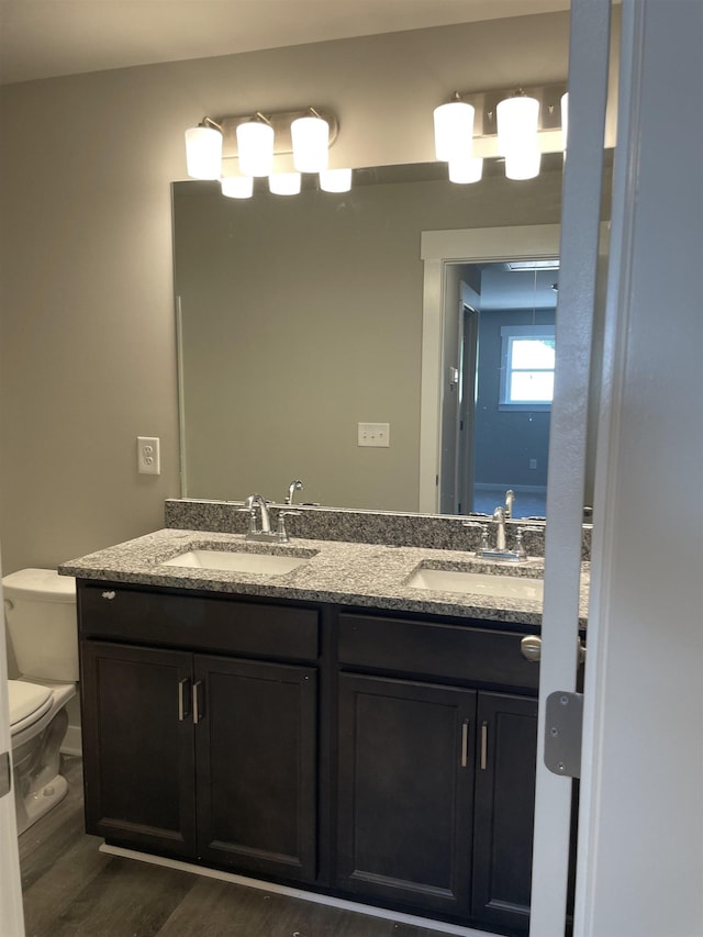 bathroom featuring vanity, hardwood / wood-style flooring, and toilet