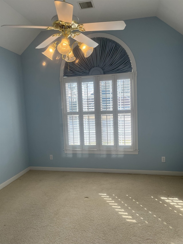 carpeted empty room featuring vaulted ceiling and ceiling fan