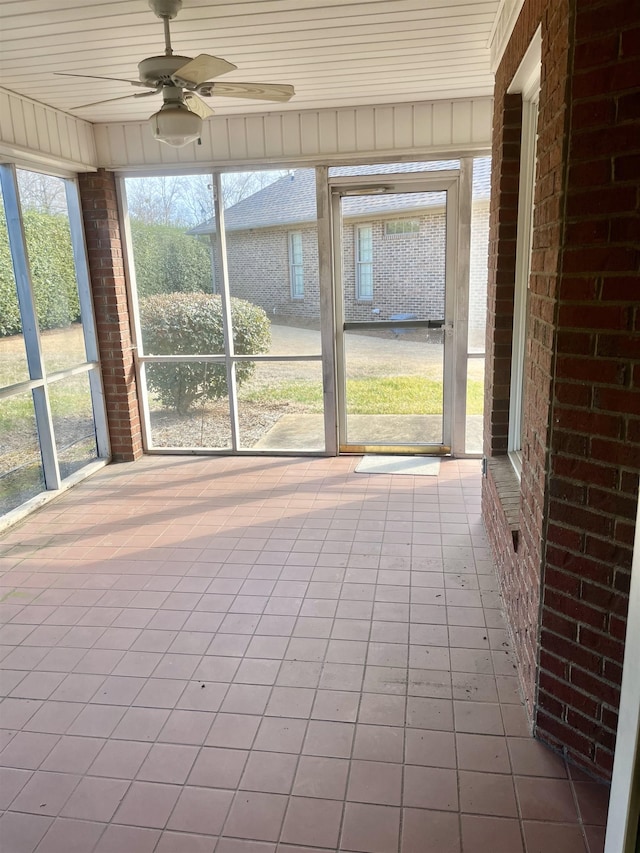 unfurnished sunroom featuring ceiling fan