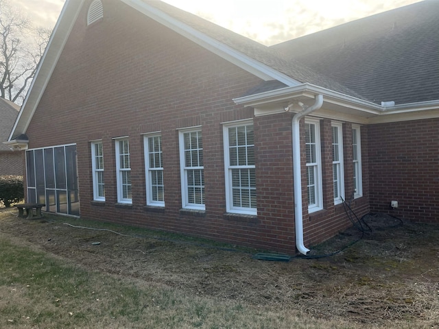 property exterior at dusk featuring a sunroom