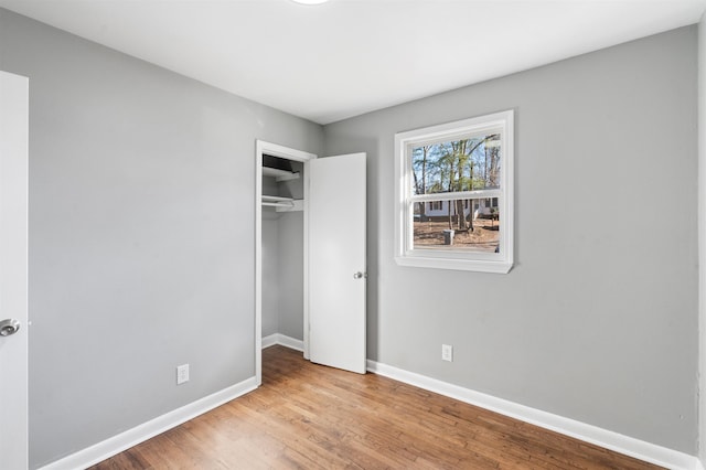 unfurnished bedroom with light hardwood / wood-style flooring and a closet