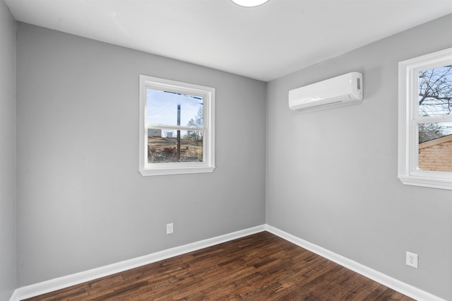 empty room with a healthy amount of sunlight, a wall mounted AC, and dark wood-type flooring