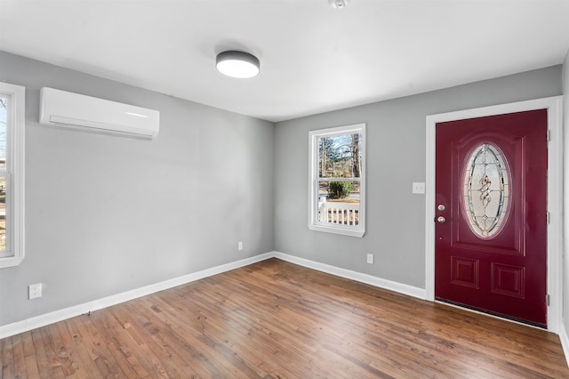 foyer featuring dark wood-type flooring and a wall unit AC