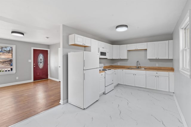 kitchen with sink, white appliances, wooden counters, and white cabinets