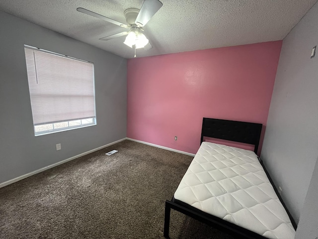 unfurnished bedroom with ceiling fan, carpet, and a textured ceiling