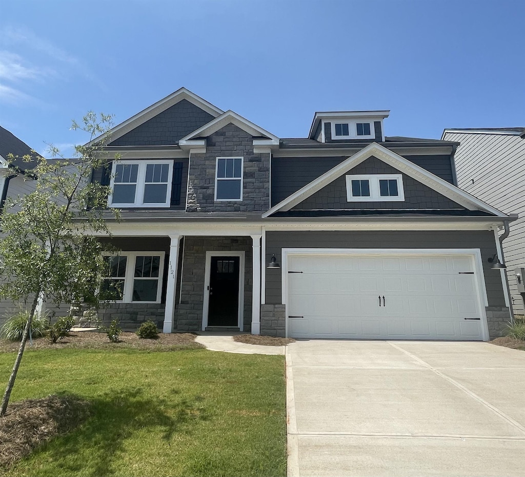 craftsman-style house featuring a garage and a front lawn