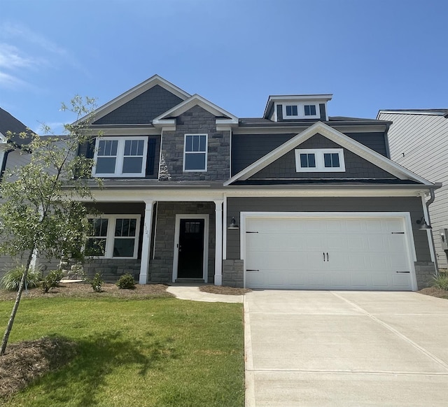 craftsman-style house featuring a garage and a front lawn